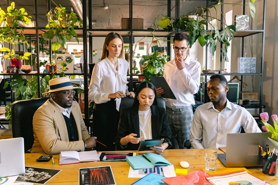 Une équipe examine des graphiques financiers et des données numériques sur des tablettes dans un environnement de bureau.