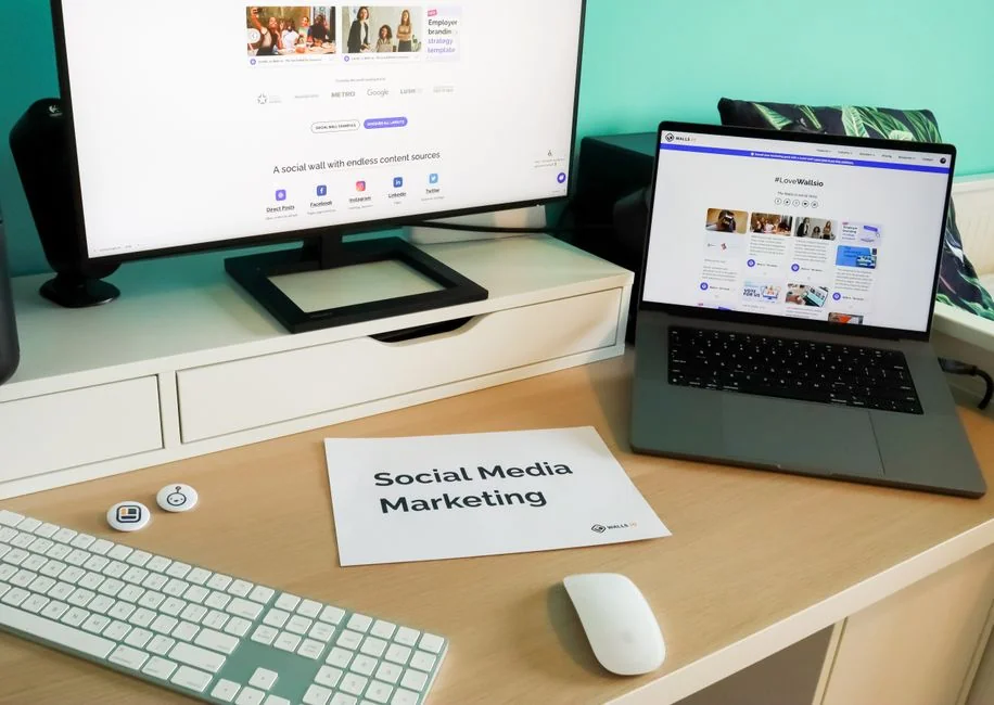 A modern workspace showing hands analyzing marketing data on a laptop and paper documents.